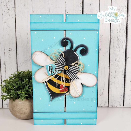 Decorative bee-shaped box with a bow on a wooden background