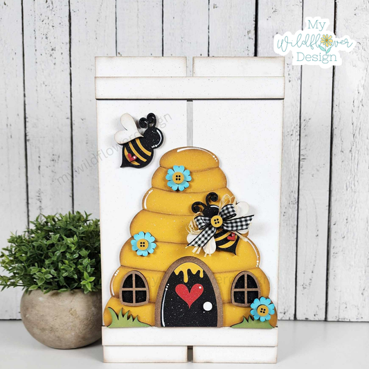 Decorative wooden bee hive with bees and flowers on a white background