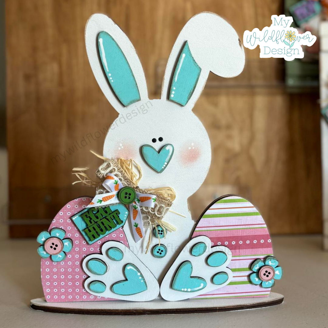 Decorative wooden bunny with colorful details on a wooden surface