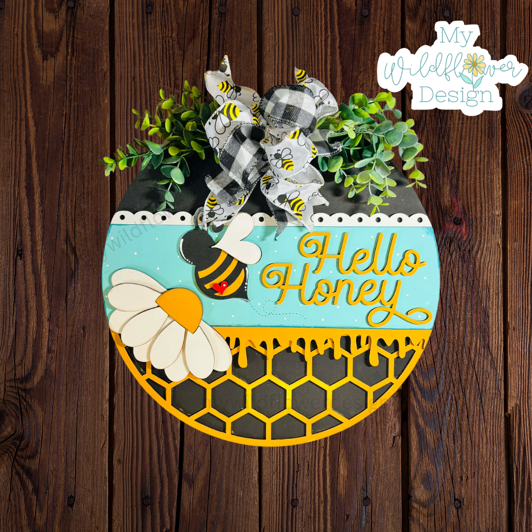 Decorative sign with bee design and 'Hello Honey' text on a wooden background
